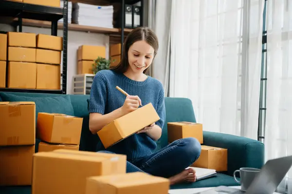 Beyaz kadın KOBİ akıllı telefon ya da tablet kullanarak çalışıyor online alışveriş siparişlerini alıyor ve kontrol ediyor, serbest iş çevrim içi konsepte