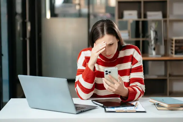 İş kadını, modern ofiste tablet üzerinde çalıştığı için stresli, sıkılmış ve aşırı düşünüyor.