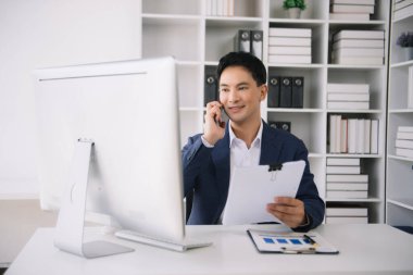 Genç iş adamı çalıştığı yerde bilgisayarını ve tabletini kullanıyor. İşine odaklan.
