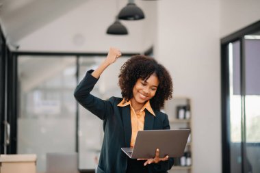 Asyalı iş kadını tablet, dizüstü bilgisayar üzerinde yaptıkları işten memnun ve memnun.