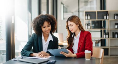 İki iş adamı akıllı telefondan konuşuyor ve Modrrn ofisinde dizüstü bilgisayar kullanıyorlar.