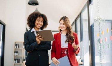 İki iş adamı akıllı telefondan konuşuyor ve Modrrn ofisinde dizüstü bilgisayar kullanıyorlar.