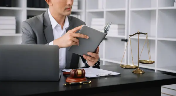 Adalet ve hukuk kavramı. Tahta masadaki bir mahkeme salonunda erkek yargıç ve modern ofiste çalışan avukat veya erkek avukat..