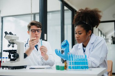 Tablet ve dizüstü bilgisayarı, laboratuarı ve çevre dostu bilimi olan iki bilim adamı. Çevrimiçi okuma ile tarım, araştırma ve bilim adamları, küresel ısınma, analitik ve teknoloji için test örnekleri