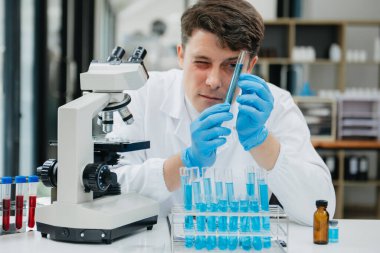 Olgun Erkek biyoteknoloji uzmanı laboratuvarda yeni kimyasal maddeler test ediyor.