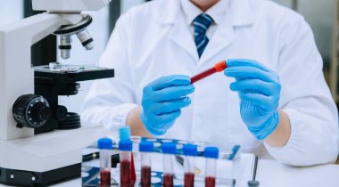 Olgun erkek bilim adamı bir laboratuarda deney yapıyor.