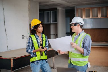 Mühendisler, büyük bir proje üzerinde yeni inşaat sahasında mimari projeyle veri çalışması ve dizüstü veya tablet üzerinde görüşüyorlar. Sabah...