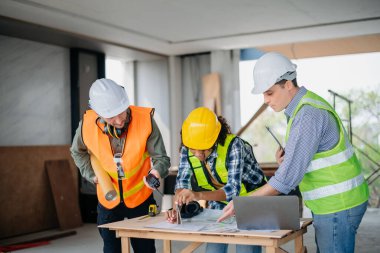 Mimar beyaz adam inşaat alanında meslektaşlarıyla karışık ırk üzerinde çalışıyor. Büyük projede mimarlık mühendisliği. İnşaat sürecinde bina içi.