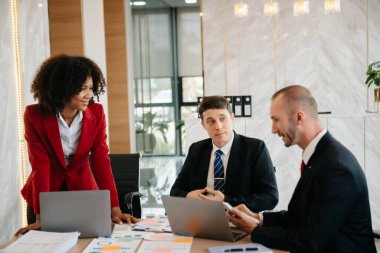 İş adamlarından oluşan bir grup modern girişimde iş planlarını tartışıyor yaratıcı iş dünyasında modern ofisi tartışıyorlar. 