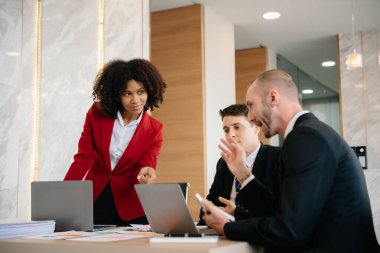 İş adamlarından oluşan bir grup modern girişimde iş planlarını tartışıyor yaratıcı iş dünyasında modern ofisi tartışıyorlar. 