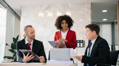 Genç iş adamları beyin fırtınası yapıyor. Yaratıcılık sektöründe oturup modern ofisteki işleri tartışıyorlar.