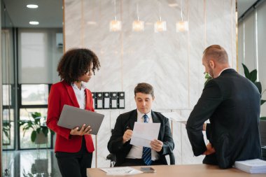 Genç iş adamları beyin fırtınası yapıyor. Yaratıcılık sektöründe oturup modern ofisteki işleri tartışıyorlar.