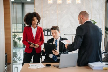 Genç iş adamları beyin fırtınası yapıyor. Yaratıcılık sektöründe oturup modern ofisteki işleri tartışıyorlar.