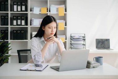 Tablet ve dizüstü bilgisayarda yazan genç ve güzel bir kadın. Çalışan ahşap masa, modern ofis.