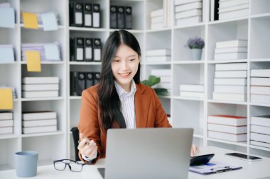 Tablet ve dizüstü bilgisayarda yazan genç ve güzel bir kadın. Çalışan ahşap masa, modern ofis.