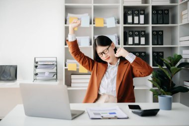 Ofis masasında uzun bir gün geçirdikten sonra boynu ağrıyan Asyalı genç işkadını ofis çalışanı. ofis sendromu kavramı