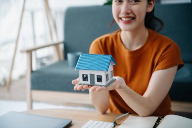 Emlak komisyoncusu, müşteriye ipotek kredisi teklifiyle ilgili sözleşme imzalama, ev modeli alma ve satma kararını sunar.