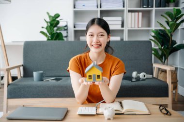 Emlak komisyoncusu, müşteriye ipotek kredisi teklifiyle ilgili sözleşme imzalama, ev modeli alma ve satma kararını sunar.