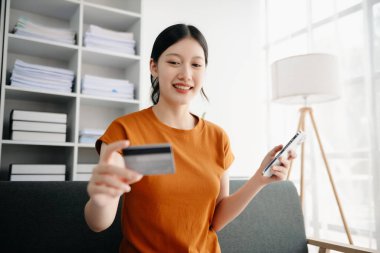 Akıllı telefon kullanan ve kredi kartı tutan Asyalı genç kadın elleri. Çevrimiçi Alışveriş Ödemeleri kavramı