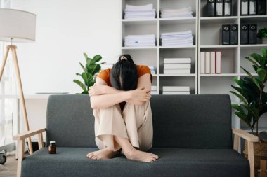 Asya 'lı genç bir kadın depresyonda oturuyor koyu saçlı dalgın bakışlar pencere kenarında duruyor ve anksiyete kopyalama alanı.