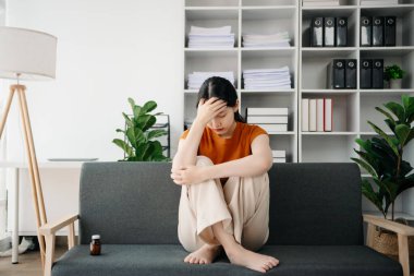 Asya 'lı genç bir kadın depresyonda oturuyor koyu saçlı dalgın bakışlar pencere kenarında duruyor ve anksiyete kopyalama alanı.