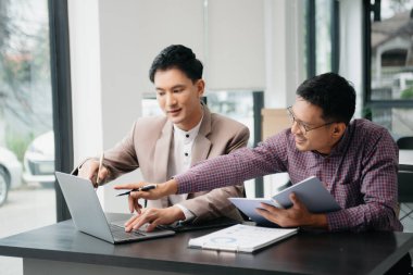Ofisteki bilgisayarda çalışan iki genç iş arkadaşı birlikte bir proje üzerinde çalışıyorlar.