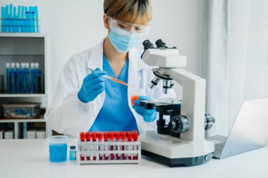 Modern tıbbi araştırma laboratuvarı. Kadın bilim adamı mikro pipetlerle çalışıyor biyokimyasal örnekleri analiz ediyor, tıp için ileri bilim kimya laboratuvarı.