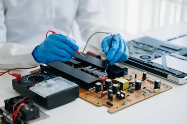 Elektronik teknisyen, elektronik mühendisliği, elektronik onarım, ölçüm ve test, onarım ve bakım kavramları. Kontrol ve yükseltme için voltaj ölçer kullanır 