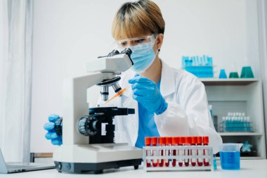 Modern tıbbi araştırma laboratuvarı. Kadın bilim adamı mikro pipetlerle çalışıyor biyokimyasal örnekleri analiz ediyor, tıp için ileri bilim kimya laboratuvarı.