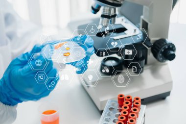 DNA molekül testi konseptleri. Maskeli doktor kimya laboratuvarındaki DNA moleküllerini sanal ikon ekran ile inceliyor.
