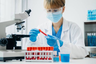 Modern tıbbi araştırma laboratuvarı. Kadın bilim adamı mikro pipetlerle çalışıyor biyokimyasal örnekleri analiz ediyor, tıp için ileri bilim kimya laboratuvarı.