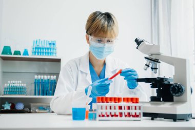 Modern tıbbi araştırma laboratuvarı. Kadın bilim adamı mikro pipetlerle çalışıyor biyokimyasal örnekleri analiz ediyor, tıp için ileri bilim kimya laboratuvarı.
