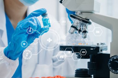 DNA molekül testi konseptleri. Maskeli doktor kimya laboratuvarındaki DNA moleküllerini sanal ikon ekran ile inceliyor.
