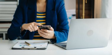 Ofiste bilgisayar, tablet ve akıllı telefon kullanan bir iş kadını. Dijital pazarlama medya mobil uygulaması ve yeni başlangıç planı tartışması. 
