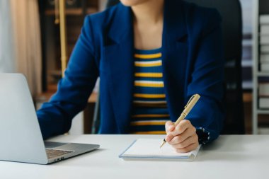 Ofiste bilgisayar, tablet ve akıllı telefon kullanan bir iş kadını. Dijital pazarlama medya mobil uygulaması ve yeni başlangıç planı tartışması. 