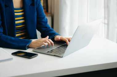 Ofiste bilgisayar, tablet ve akıllı telefon kullanan bir iş kadını. Dijital pazarlama medya mobil uygulaması ve yeni başlangıç planı tartışması. 