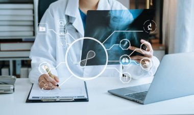 Dijital tablet ve akıllı telefon kullanan tıp doktoru arayüz üzerinde sanal elektronik tıbbi kayıtları teşhis etti. Sanal tıbbi teknolojide dijital sağlık ve ağ