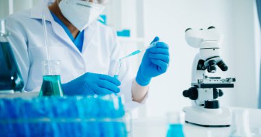 Erkek bilim adamı, kimya laboratuvarında bir deney yürütüyor.