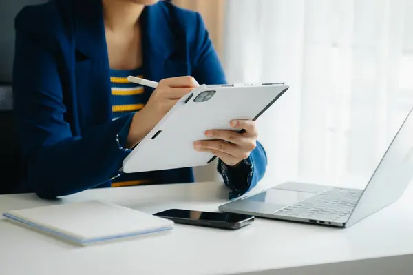 Ofiste bilgisayar, tablet ve akıllı telefon kullanan bir iş kadını. Dijital pazarlama medya mobil uygulaması ve yeni başlangıç planı tartışması. 
