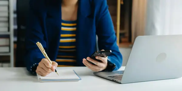 Ofiste bilgisayar, tablet ve akıllı telefon kullanan bir iş kadını. Dijital pazarlama medya mobil uygulaması ve yeni başlangıç planı tartışması. 