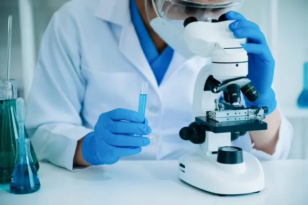 Erkek bilim adamı, kimya laboratuvarında bir deney yürütüyor.