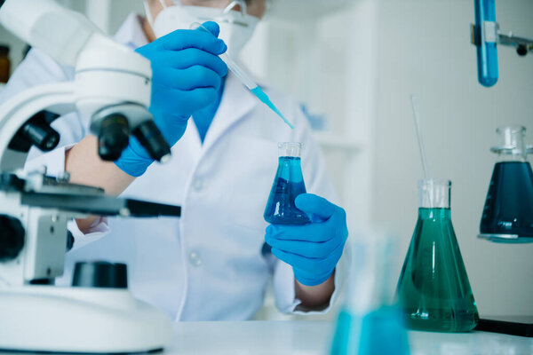 Исследователь-мужчина проводит эксперимент, работающий в химической лаборатории