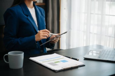 Woman freelancer is working her job on computer tablet and laptop Doing accounting analysis report real estate investment data, Financial at office