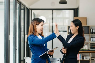 İş kadını takım toplantısını yönetiyor ve birlikte çalışma ofisinde mali durumuyla birlikte tablet ve dizüstü bilgisayar kullanıyor