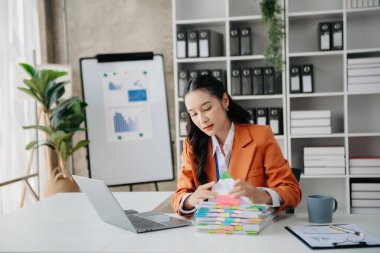 Tablet ve dizüstü bilgisayarda yazan genç ve güzel bir kadın. Çalışan ahşap masa, modern ofis.