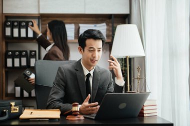 Asyalı iş adamları ve avukatlar masada oturmuş sözleşme belgelerini tartışıyorlar. Hukuk kavramları, tavsiyeler, hukuk hizmetleri. Sabah aydınlığında.