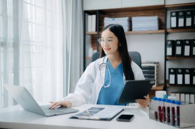 Tıbbi teknoloji konsepti. Ofisteki cep telefonu ve steteskopla çalışan bir doktor.