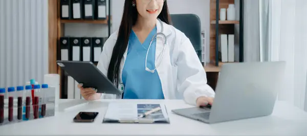 Tıbbi teknoloji konsepti. Ofisteki cep telefonu ve steteskopla çalışan bir doktor.