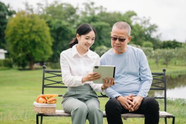 Mutlu yetişkin torun ve büyükbaba dışarıda otururken eğleniyor.