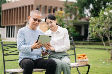Mutlu yetişkin torun ve büyükbaba dışarıda otururken eğleniyor.